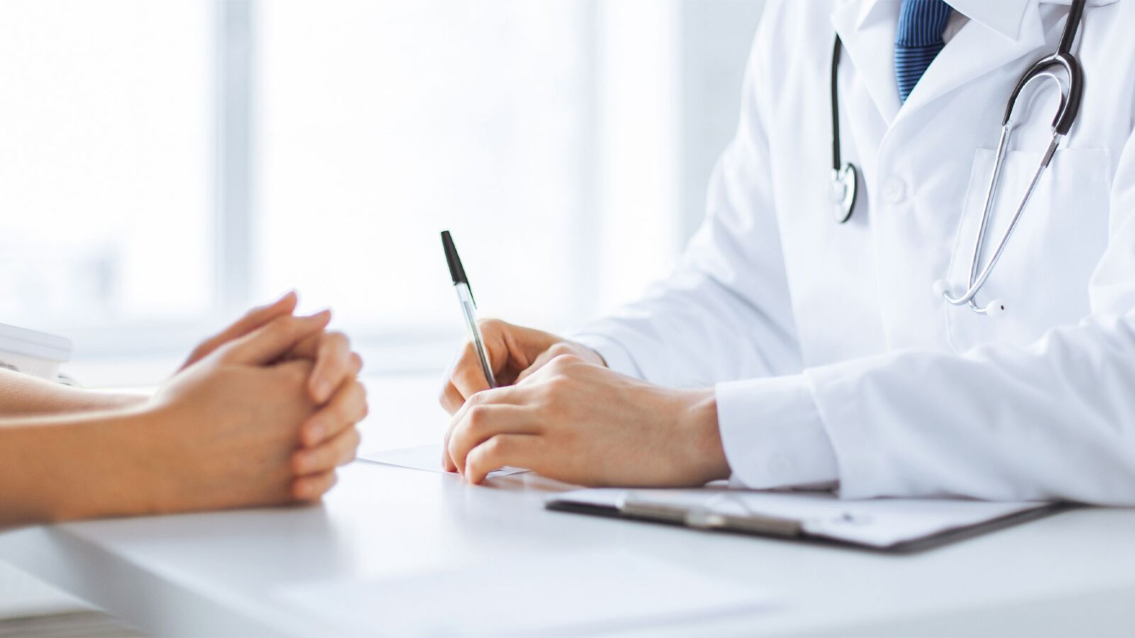 Arzt ist im Gespräch mit einem Patient / einer Patientin und hält einen Stift in der Hand