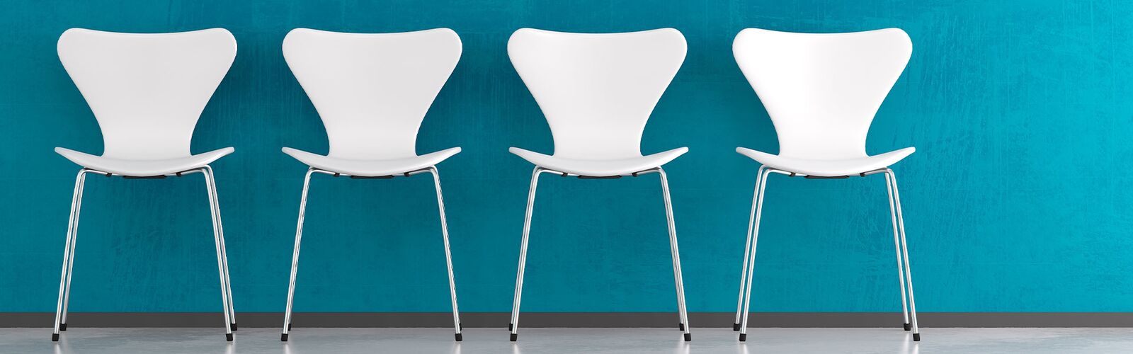 Vier Stühle vor einer blauen Wand